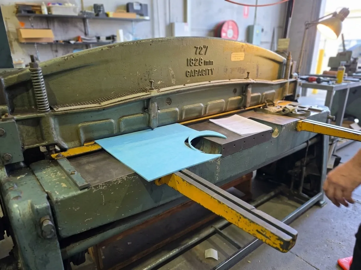 Industrial guillotine shear cutting a wide gasket sheet